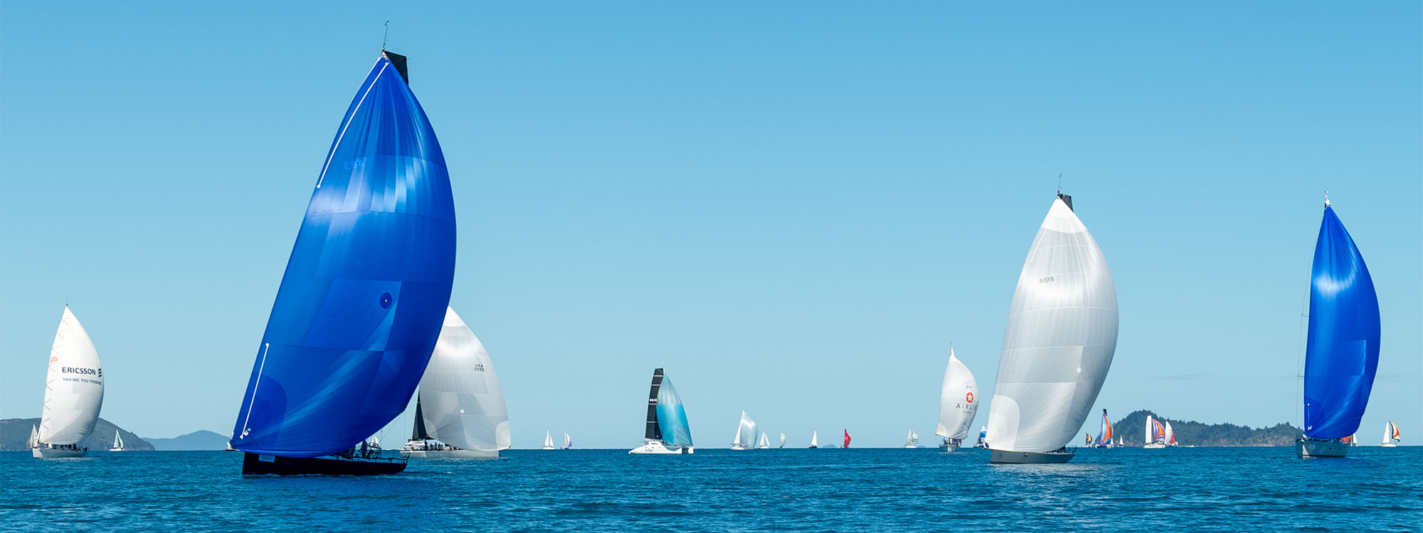 Sailing boats with blue and white sails on a clear day